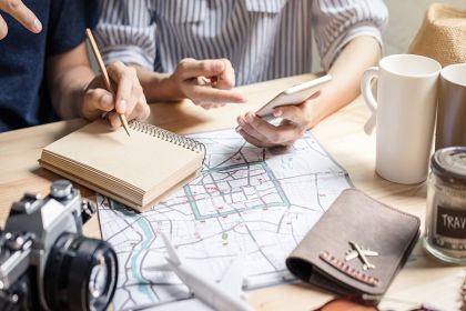 Travelers planning an Orlando vacation with a map, notebook and coffee
